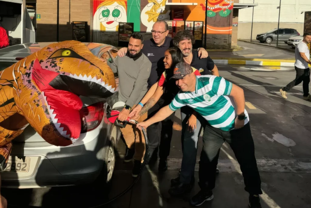 Ação Sem Imposto da Minaspetro com fantasia de dinossauro em posto.