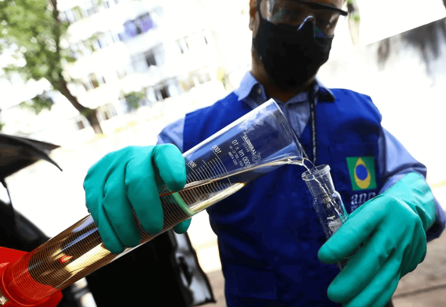 Homem realizando teste de combustível com equipamento de laboratório.