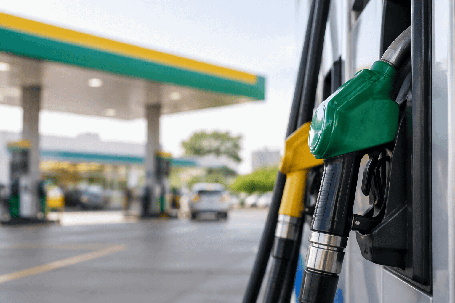 Bomba de combustível verde em destaque ao lado de cabos em posto de gasolina Minaspetro.